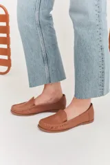 Mocasines de cuero color marrón claro con costuras a la vista.