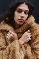 Campera corta de corte holgado confeccionada en tejido sintético con efecto de pelo largo. Presenta cuello clásico, cierre frontal oculto mediante corchetes y forro interior.