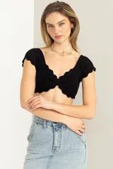 Crop top tejido negro con escote sweetheart, mangas cortas y diseño artesanal en crochet.