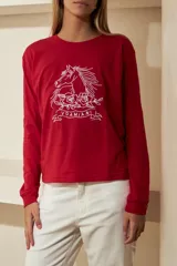 Remera negra de manga larga confeccionada en algodón, con cuello redondo y estampado de un caballo con rosas y la palabra "VDAMIANI" en color blanco.