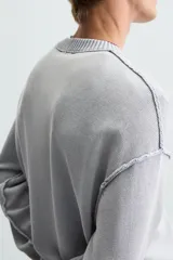 Sweater negro de algodón con cuello redondo y mangas largas. Tiene un acabado lavado con efecto desgastado y rib en cuello, puños y bajo.