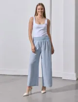 Pantalón largo de poliéster color beige con rayas verticales, pretina ancha elastizada en punto smock y pierna ancha.