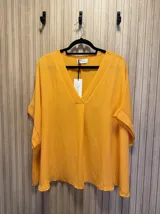 Blusa negra de corte holgado con escote en V y mangas cortas con dobladillo.
