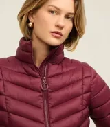 Campera puffer ultraligera color marrón, confeccionada en poliamida acolchada, con cuello alto y cierre por cremallera. Incluye bolsita con cordón.