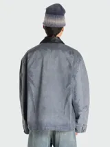 Campera azul grisáceo con cuello clásico de cuero negro, cierre frontal con cremallera, manga larga, puños con botón a presión, dos bolsillos laterales con solapa y un bolsillo interior.