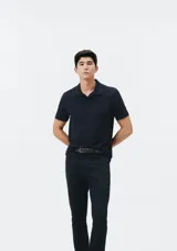 Camiseta tipo polo de manga corta, color azul oscuro, con cuello y tapeta de dos botones.