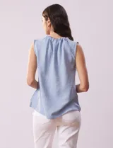 Blusa sin mangas color beige, de crepe. Cuello a la base con frunce, apertura ojal y botón.
