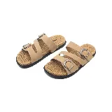 Sandalias bajas color beige con dos tiras anchas con hebillas metálicas plateadas y suela de goma negra.