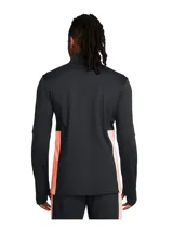 Buzo deportivo Under Armour Challenger de hombre, color naranja con paneles laterales en gris oscuro, cuello alto con cierre de cremallera corto, mangas largas con orificios para los pulgares y logo de la marca estampado en el pecho.