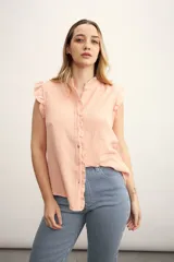 Camisa color amarillo pálido con cuello mao, sin mangas, con volados en los hombros y en el frente.