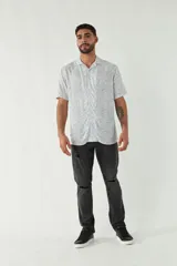 Camisa celeste con estampado de hojas, de corte slim, manga corta, cartera abotonada y logo bordado.