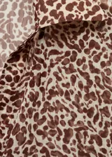 Camisa de estampado animal print con cuello clásico y botones frontales, de manga larga y corte suelto.