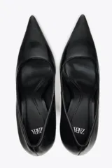 Zapato de tacón fino color negro, con escote redondo y acabado en punta.