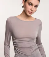 Blusa de viscosa color gris con efecto gastado, cuello redondo, mangas largas, fruncido lateral y abertura.