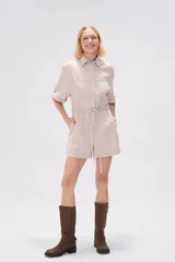 Mono corto blanco de algodón, con cuello camisero, cierre frontal con botones, mangas cortas y bolsillos.