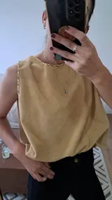 Chaleco dorado sin mangas con cuello redondo y corte holgado.