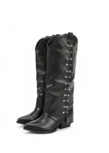 Botas negras de caña alta con punta en pico y taco bajo. Presentan detalles metálicos plateados en forma de ojales a lo largo de la caña.