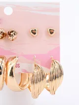 Set de seis pares de aros dorados con diferentes diseños: aros tipo perla, aros con forma de nudo, aros con forma de corazón, aros tipo argolla trenzada, aros tipo argolla lisa y aros con diseño de hojas.