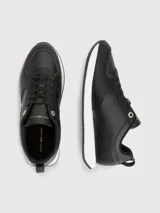 Zapatillas deportivas Tommy Hilfiger negras de cuero sintético, con cordones y suela blanca.