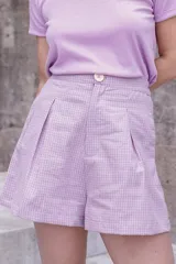 Bermuda de lino y algodón a cuadros color lila y blanco, con botón a la vista y pinzas en la cintura.