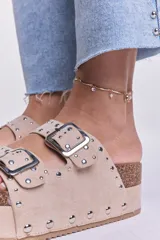 Sandalias beige con plataforma de corcho y doble tira con hebillas y tachas plateadas.