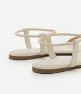 Sandalia plana color crema con punta de hoja, tira elástica en el talón y tiras dobles cubiertas de strass en la parte superior.