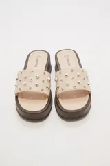 Sandalias color beige con plataforma marrón y apliques de tachas plateadas.