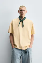Camiseta color arena de algodón compacto, corte recto, cuello redondo y mangas cortas.