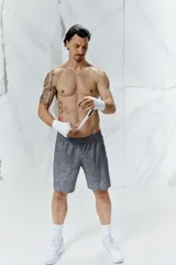 Short deportivo gris con estampado de mármol, de corte estándar, con cintura elástica y cordón de ajuste oculto, bolsillos laterales con cierre, orificios de ventilación cortados a láser y abertura lateral en el bajo.