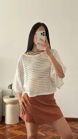 Short pollera color negro confeccionado en viscosa, poliéster y lino, con cierre de botón lateral.