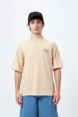 Remera color beige con cuello redondo y mangas cortas. Estampado pequeño en el frente con la frase "Spritz and Shine".