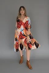 Vestido camisero midi con volados, estampado con hojas de colores y cierre frontal con botones.