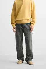 Pantalón color marrón con efecto lavado, corte relaxed fit, cinco bolsillos, aplicación de tira y bolsillo multifunción en perneras, cierre frontal con cremallera y botón.
