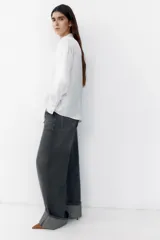 Camisa blanca de satén con cuello solapa, escote en pico, manga larga y cierre frontal con botones.