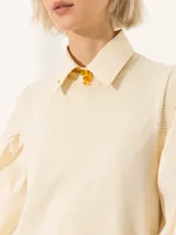Sweater color crema de tejido de punto fino, con cuello redondo y mangas largas abullonadas.