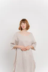 Vestido midi de lino con corte relajado y silueta fluida. Presenta escote redondo, mangas 3/4 y bolsillos laterales. Diseño minimalista y atemporal ideal para el verano.
