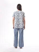 Remera celeste con estampado de hojas blancas.