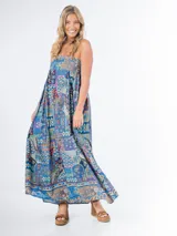 Vestido largo de algodón con estampado geométrico multicolor, corte cuadrado, elástico en la espalda y tirantes finos. Incluye aplique de flor desmontable.