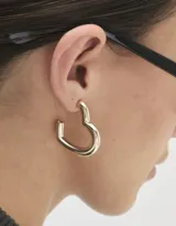 Aros dorados tipo argolla con forma de corazón y cierre a presión.