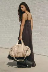 Mono largo color negro, con tirantes finos, escote cuadrado, cuerpo ligeramente entallado, cintura estilo imperio y pantalones de pierna ancha y relajada. Incluye bolsillos laterales.