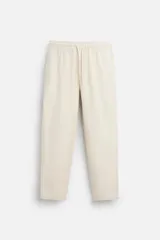 Pantalón color crudo de corte recto, con cintura elástica ajustable con cordón, bolsillos laterales y traseros de vivo.