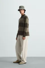 Polo relaxed fit de punto tejido en hilatura de algodón, a rayas horizontales en tonos azul y negro. Cuello solapa con cierre frontal de botonadura, manga larga y acabados en rib.