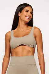 Top deportivo gris con escote cuadrado, breteles anchos y calce ajustado. Incluye forro interno y apertura para almohadilla removible.