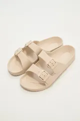 Sandalias tipo Birkenstock color beige con hebillas ajustables.