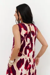 Vestido midi sin mangas, con cuello redondo, estampado animal print en tonos rojo, bordó y beige. Presenta cortes diagonales en el cuerpo que añaden estructura al diseño.