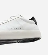 Championes casuales de cuero sintético color blanco con detalle de talón en cuero sintético negro.