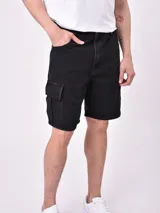 Bermuda de jean color negro, corte recto, con bolsillos laterales tipo cargo.