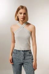 Top cropped gris metalizado con cuello halter y detalle de studs.