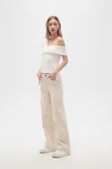 Pantalón jean color beige, de corte recto y holgado, con cintura alta y diseño color block en la parte superior.