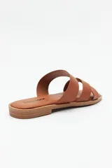 Sandalia plana color marrón con tiras anchas cruzadas, punta cuadrada y base levemente acolchonada.